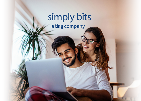 Man and woman smiling looking at a laptop